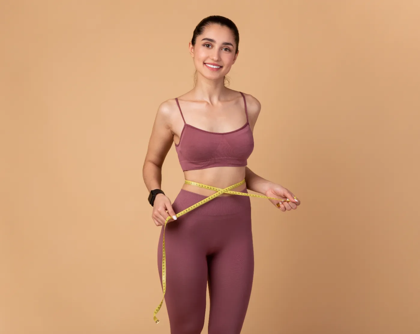 woman-measures-waist-with-tape-measure-in-studio-2026-01-09-11-08-04-utc